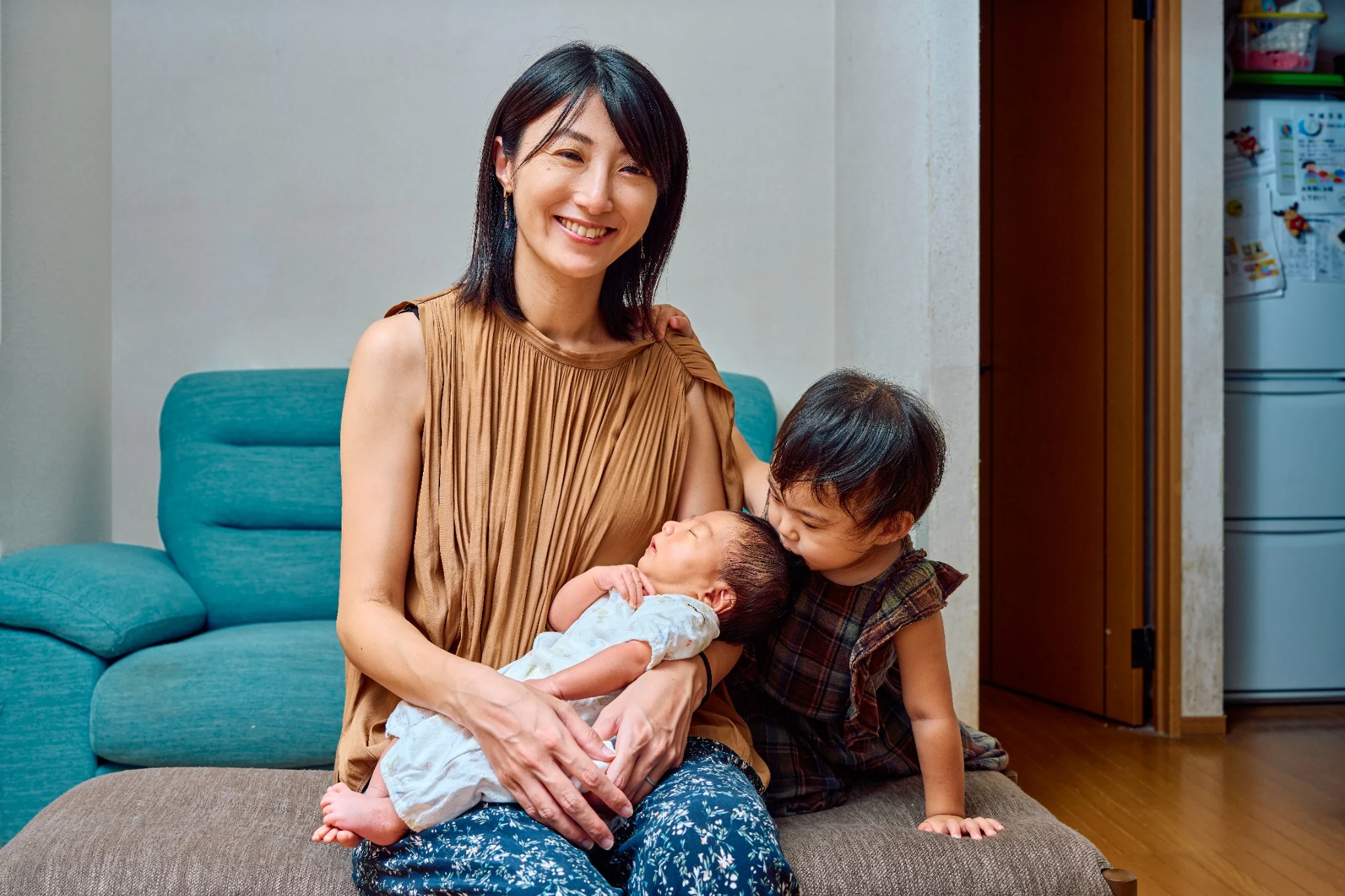 母親に抱かれた新生児ときょうだいの家族写真